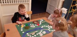 Dzieci grają w grę planszową wykonaną przez siebie