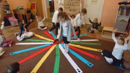dzieci bawią się i zwijają kolorowe szarfy
