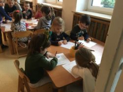 Dzieci rysują przy stoliku dinozaury