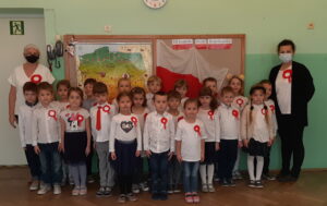 Zdjęcie grupy Biedronek w na tle flagi polski z okazji udziału w akcji "Szkoła do hymnu"