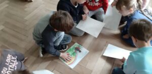 Zdjęcie dzieci oglądających rysunki na podłodze