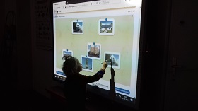 Zdjęcie dzieci pracujących na tablicy interaktywnej