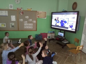zdjęcie dzieci przed monitorem w czasie zajęć online