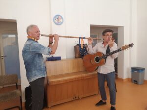 dwóch muzyków trzyma dwustronny flet