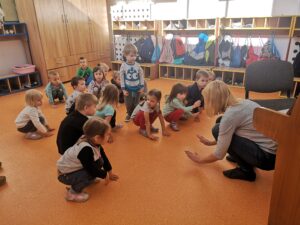 dzieci bawią się i tańczą na sali na zajęciach rytmiki