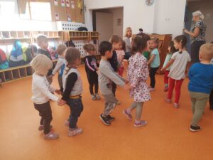dzieci bawią się i tańczą na sali na zajęciach rytmiki
