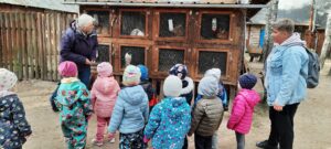 grupa dzieci ogląda króliki w klatkach