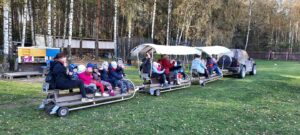 dzieci siedzą w wagonikach w kolejce