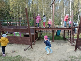 Dzieci bawią się na drewnianym statku, na dworze. 