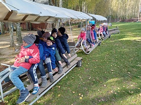 Dzieci siedzą na wagonach kolejki