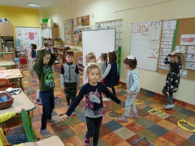 Dzieci chodzą po podłodze z nałożonymi na głowę woreczkami sensorycznymi