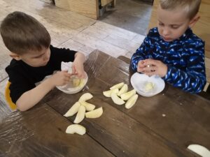 dwóch chłopców trze jabłka
