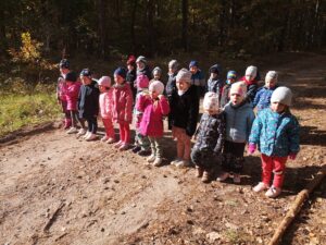 grupa dzieci stoi na drodze w lesie