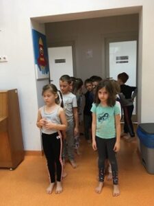 Dzieci stoją w dwóch kolumnach czekając na polecenia nauczyciela