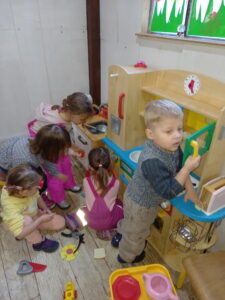 grupa dzieci bawi się w kąciku kuchennym