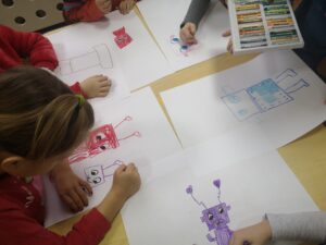 dzieci rysują roboty przy stoliku