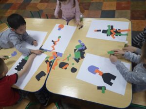 dzieci wyklejają papierowe roboty