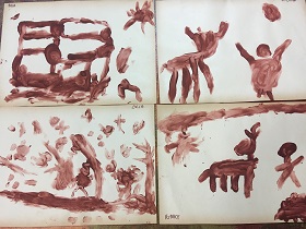 Pismo obrazkowe wykonane przez dzieci brązową farbą.