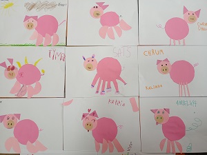 Prace plastyczne dzieci, na których przedstawione są różowe świnki, wykonane z kółek.