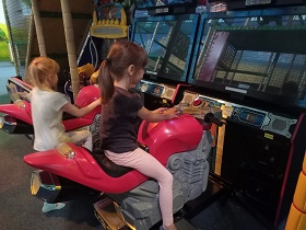 Dwie dziewczynki bawią się na motorach.
