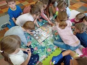 Dzieci układają magnesy na szarej tablicy. 