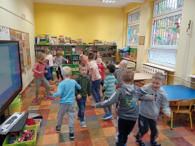 Dzieci tańczą w parach, trzymając się pod ręką. 