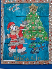 Puzzle: na niebieskim tle jest Mikołaj w czerwonym ubraniu i choinka z ozdobami. Mikołaj wiesza ozdoby na choince. Pod choinką leżą trzy prezenty zapakowane w kolorowy papier.