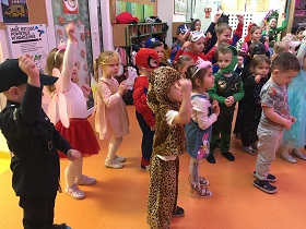 Piątka dzieci przebranych za: policjanta, wróżkę, tygrysa, księżniczkę i spidermana tańczy w sali.