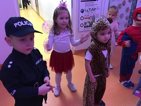 Grupka dzieci przebranych za: policjanta, księżniczki, wróżki, spidermana i tygrysa tańczy.