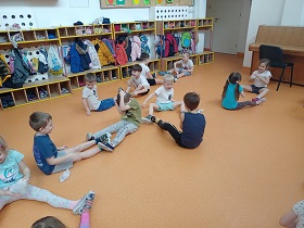 Dzieci w strojach gimnastycznych, w parach rzucają do siebie woreczkami gimnastycznymi. 