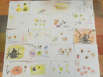Na podłodze znajdują się rysunki dzieci przedstawiające inkluzje owadów w bursztynie. 