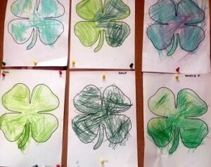 szablony koniczyn pokolorowane zielonymi kredkami przez dzieci