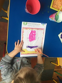 dziewczynka maluje farbami doniczkę Hiacynta.