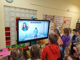 Dzieci stoją przed ekranem na którym ukazana jest postać idącego mężczyzny na niebieskim tle. Na dole ekranu znajduje się napis Tiptoe, tiptoe, tiptoe, tiptoe, tiptoe.