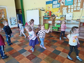 Dzieci biegają w sali przedszkolnej.