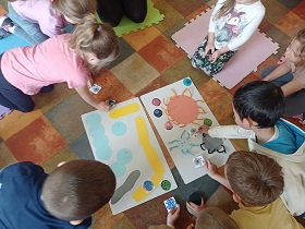 Dzieci przyporządkowują swoje kartoniki do większych plansz, na których znajdują się papierowe wirusy i bakterie. 