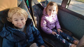 Chłopiec i dziewczynka siedzą na fotelach w autobusie