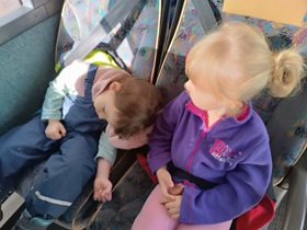 Dwie dziewczynki śpią na fotelach w autobusie