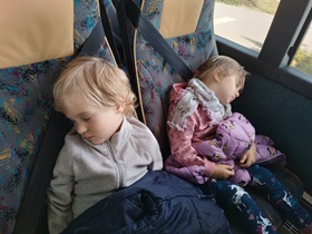 Chłopiec i dziewczynka śpią na fotelach w autobusie