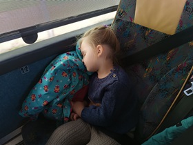 Dziewczynka śpi na fotelu w autobusie