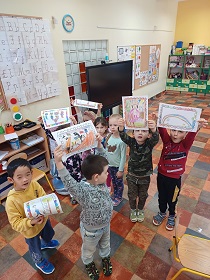 Dzieci pokazują swoje pocztówki.