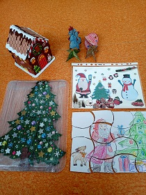 Na podłodze znajdują się puzzle przedstawiające tematykę świąteczną. 