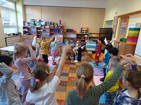 Dzieci tańczą w kole układ taneczny naśladując ruchy szkieletu, poruszanego przez Panią Karolinę