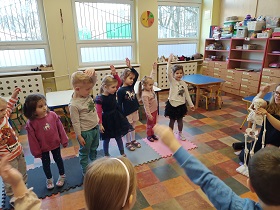 Dzieci tańczą w kole układ taneczny naśladując ruchy szkieletu, poruszanego przez Panią Karolinę.