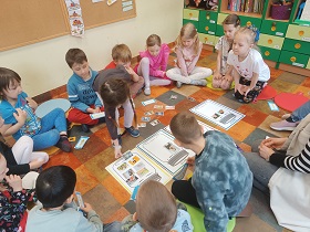 Dzieci przyporządkowują obrazki do odpowiednich ilustracji słoików. Dzieci siedzą w kółku.