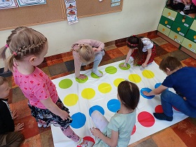 Pięcioro dzieci bawi się w grę Twister.