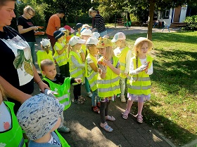 Panie i Pan rozdają dzieciom rękawiczki ochronne.