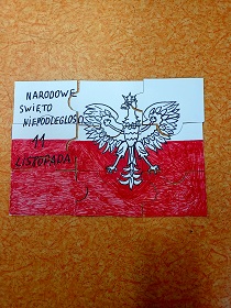 Na podłodze leżą papierowe puzzle, które nawiązują do święta niepodległości. Puzzle zostały wykonane na konkurs.