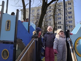 Sześcioro dzieci stoi na sprzęcie terenowym w ogrodzie przedszkolnym.