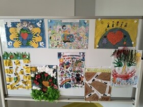 Na tablicy powieszone jest 8 prac plastycznych wykonanych przez dzieci, przedstawiających współpracę.